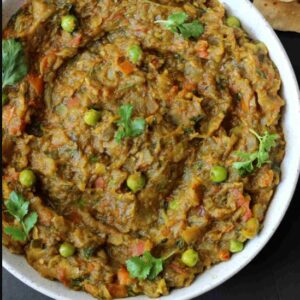 Vegan Baigan bharta is a very healthy vegetarian  Indian dish recipe that is prepared by mashing or mincing grilled eggplant (baigan) with tomato, onion, herbs and spices, cooking the eggplants over charcoals, inside of a tandoor, barbecue grill or oven, or even directly applying flame to the outside of the fruit infuses the dish with a smoky flavor.